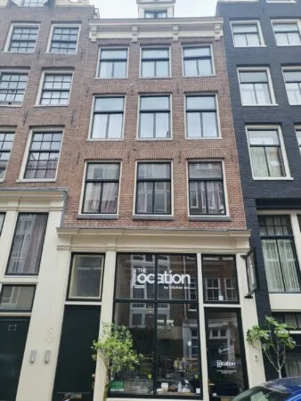 Voorgevel van een pand aan de Nieuwe Kerkstraat met het horecabedrijf “The Location by Kitchen Inc.” op de begane grond.